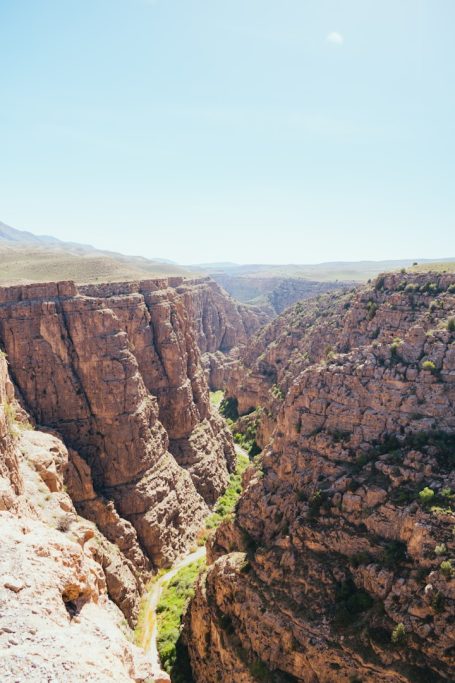 Copper Canyon Deep canyon with steep rocky walls and a lush green valley below under a clear blue sky.
