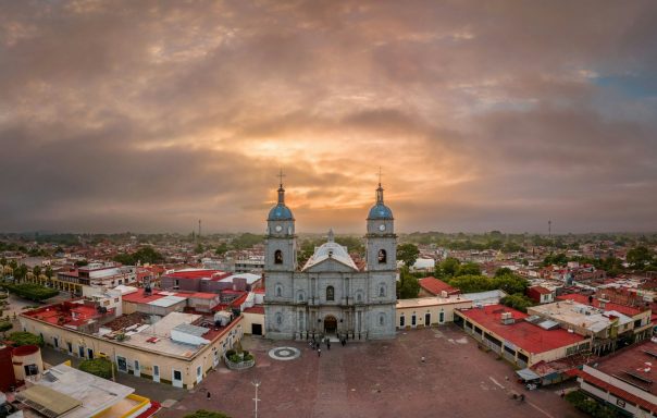 Campeche Aerial view of a historic church against a sunset sky over a town.